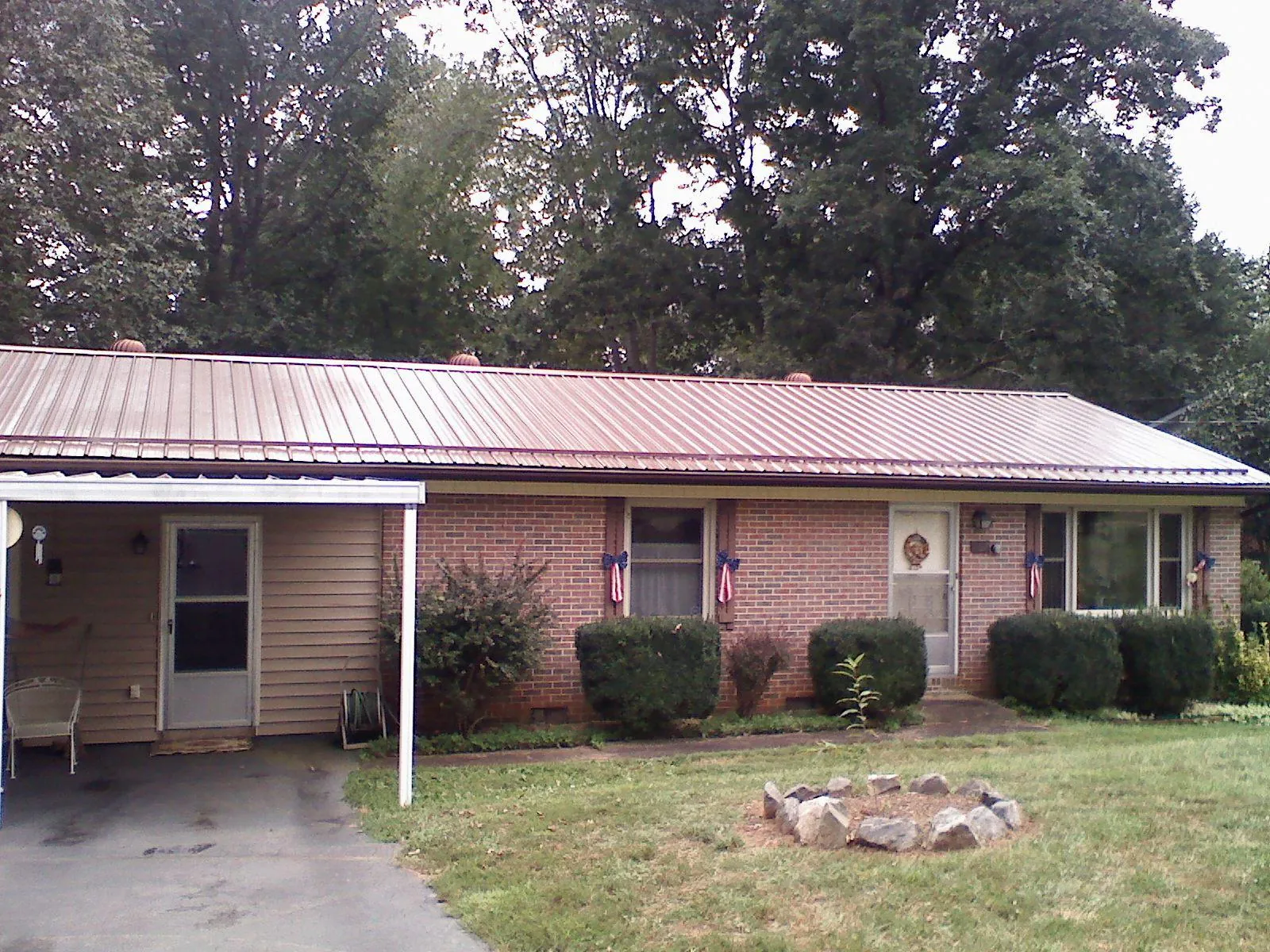 Bronze metal roof and carport on a brick ranch home — Roof Repair work by our crew in Colrain